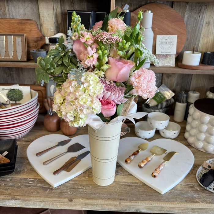 Pink rose and hydrangea arrangement on a boutique table