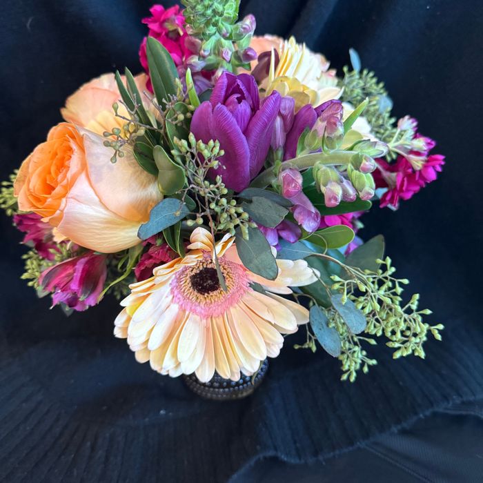 A colorful bouquet with orange rose, purple tulip, and peach gerbera
