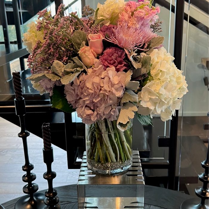 Tall purple and pink hydrangea arrangement on a private event table