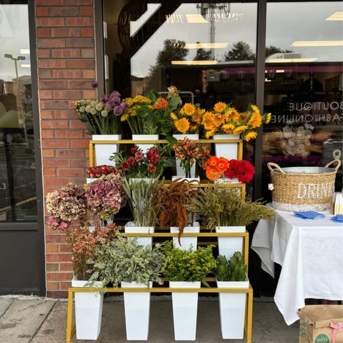 A flower cart with fresh seasonal stems set up outside Back East Home